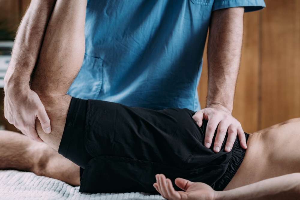 A male patient having his leg stretched by our Center Square, Blue Bell physical therapist.