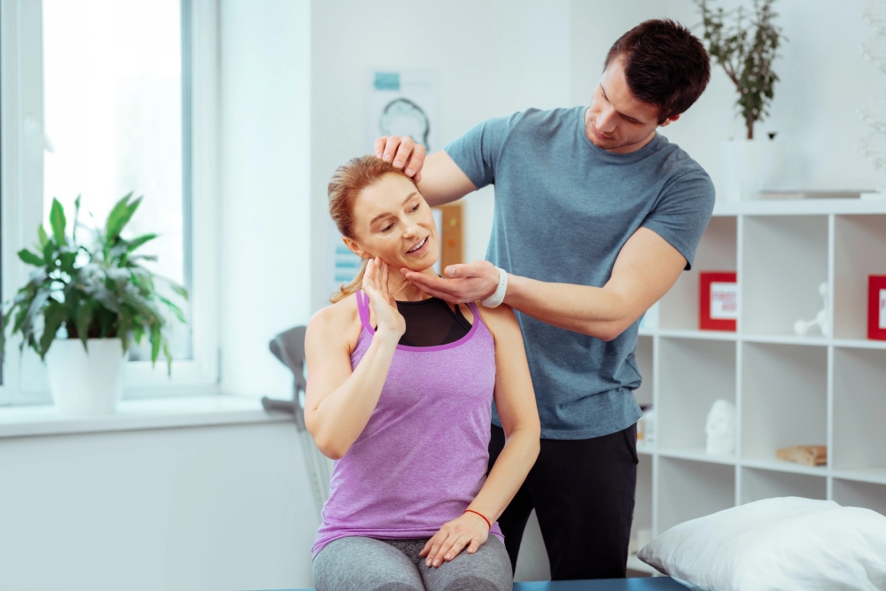 A physical therapist evaluating a female patient's head and neck as part of concussion rehabilitation therapy near Dresher, Pennsylvania.