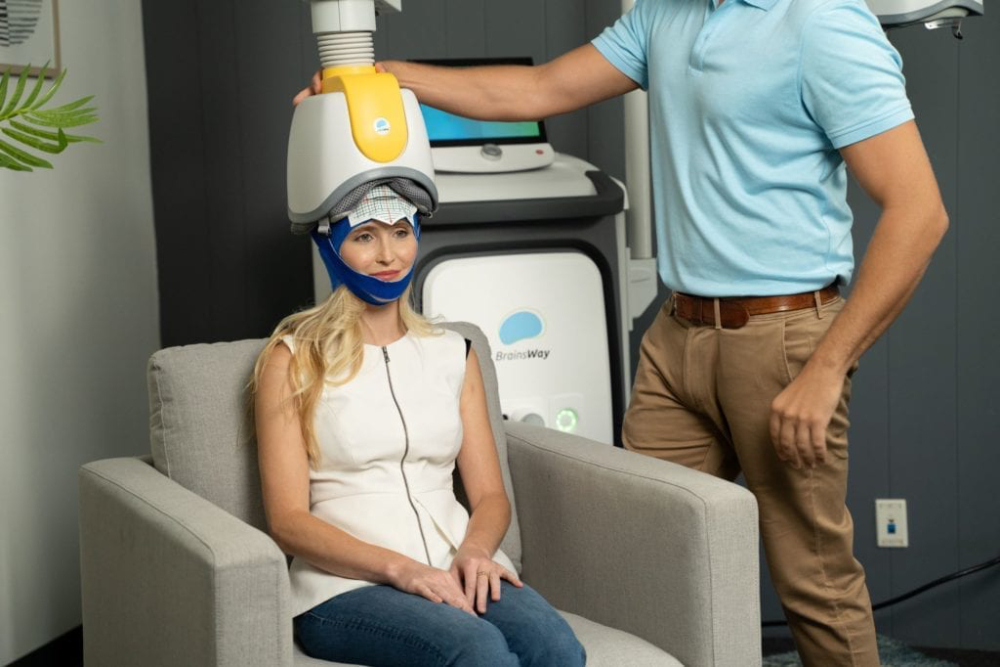 A female patient sitting in a chair with device helmet on, about to start TMS for OCD near Blue Bell, Pennsylvania.